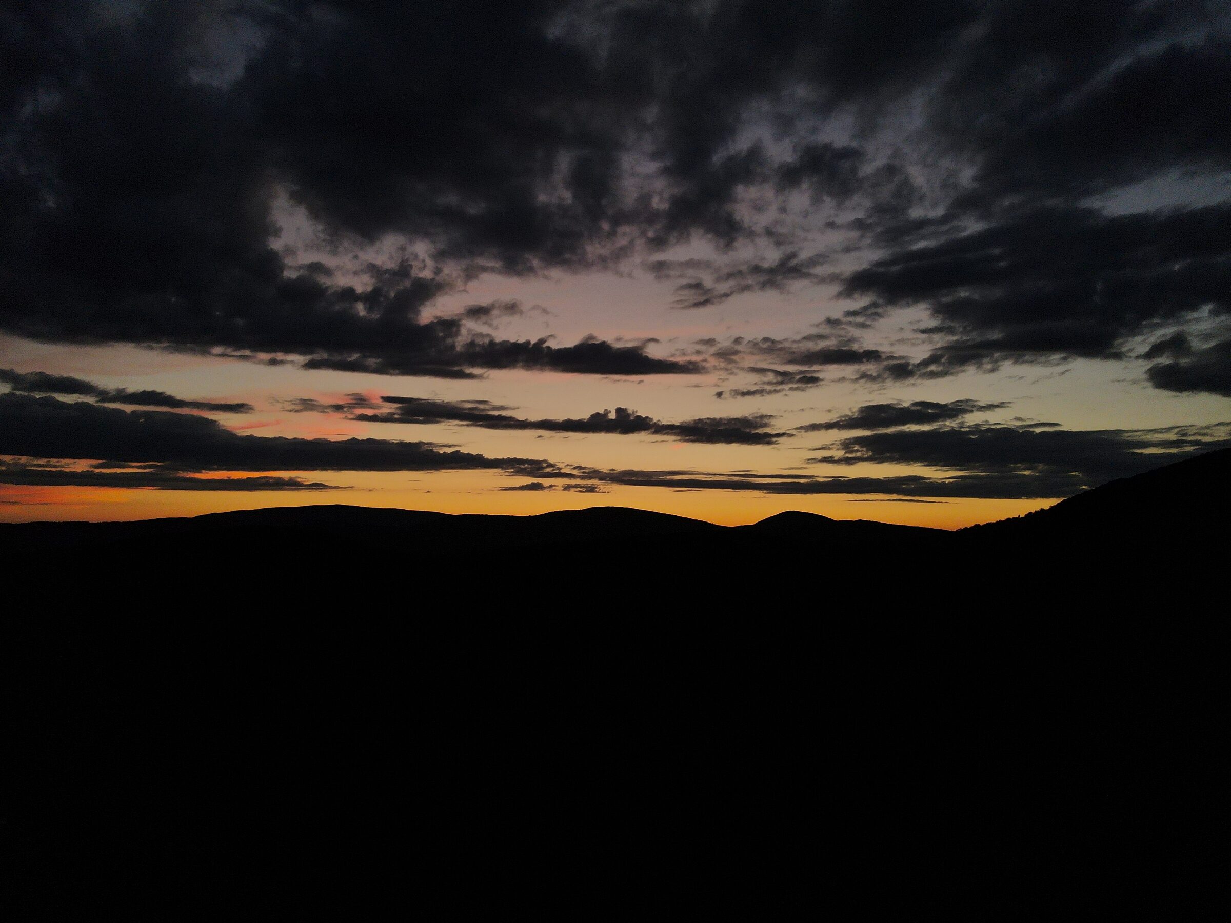Dusk light over a dark ridge line captured from the air