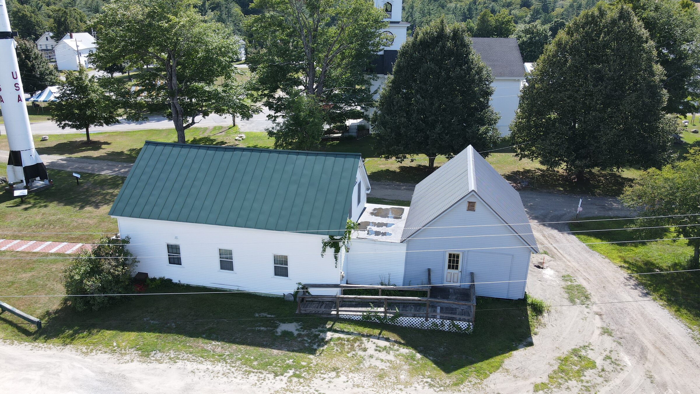 Drone photo of a white barn and outbuildings on a country road