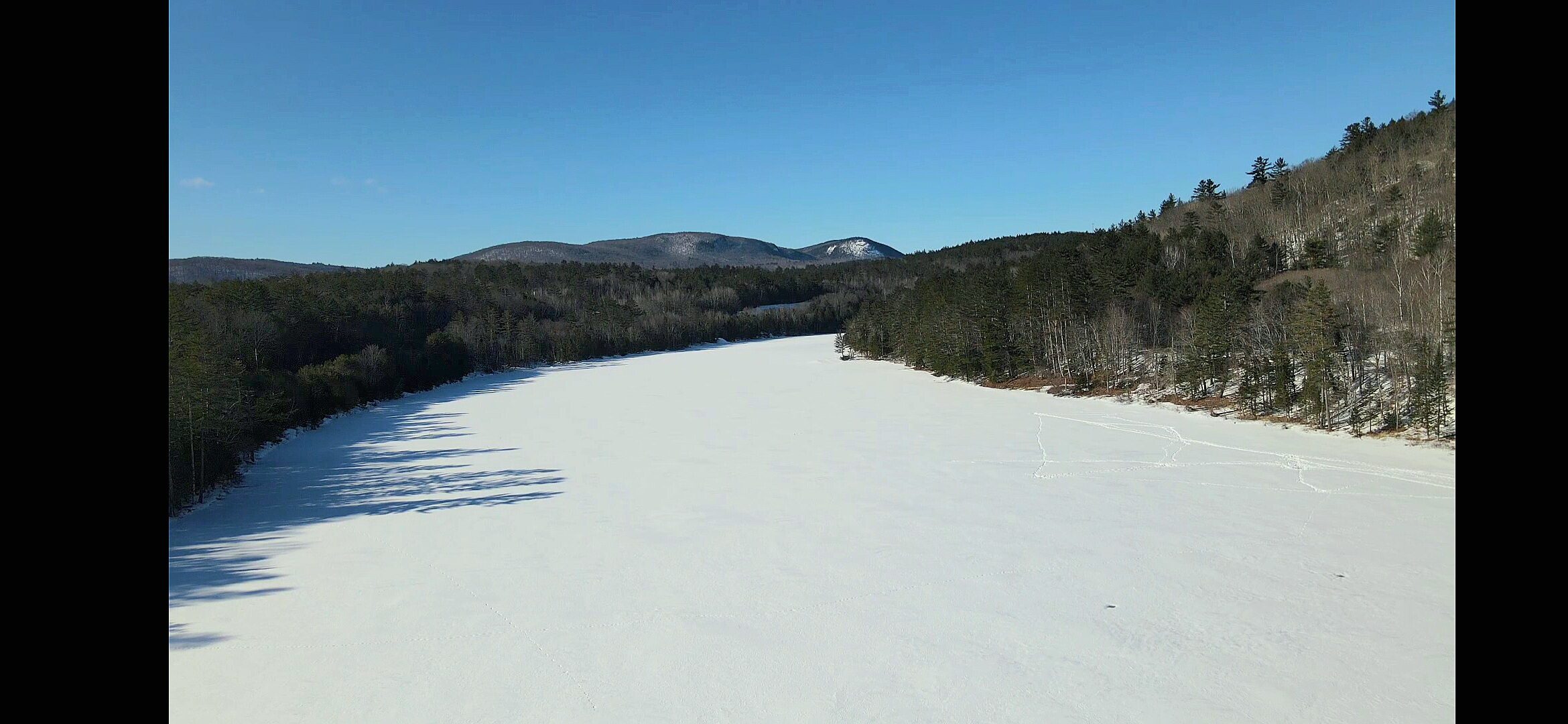 Frozen lake and snow covered ridgeline photographed from the air in winter